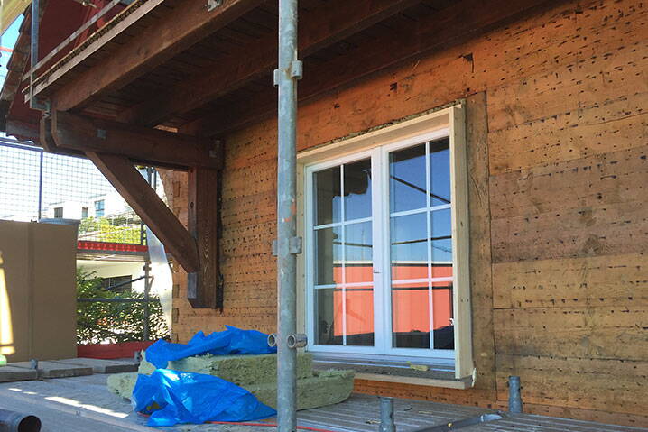 Einfamilienhaus, Stäfa Ausschnitt des Strickbaus während des Umbaus, Baumaterial und Baugerüst im Vordergrund