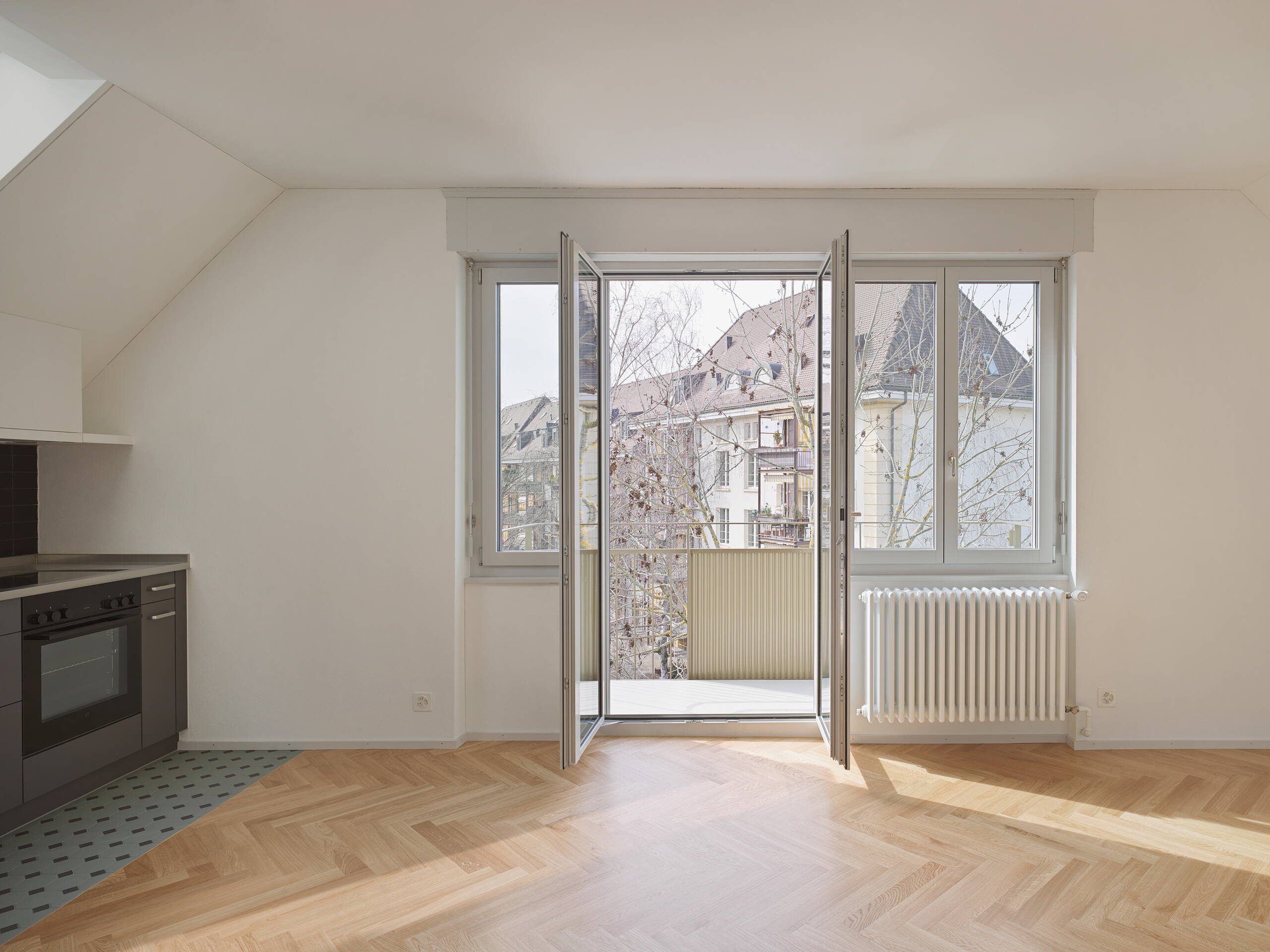 Mehrfamilienhaus, Milchbuck Zürich, Blick aus Wohnzimmer durch offene Balkontüre in Hof
