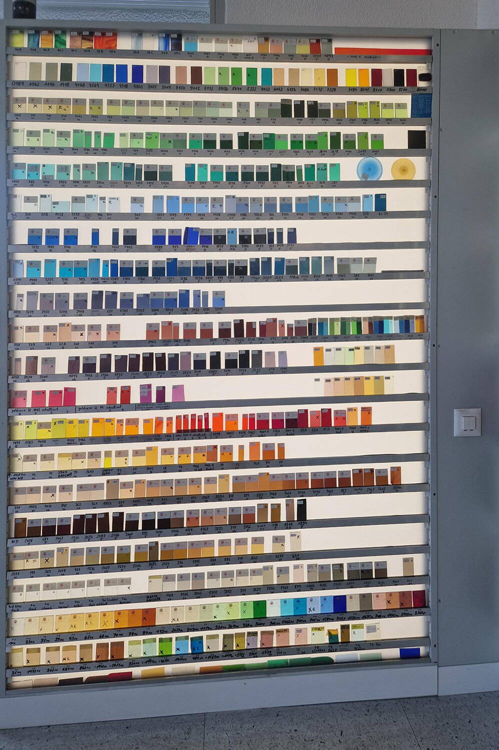 Mit dem Farbmuster-Leuchtkasten werden die Ersatzgläser für die Restauration bestimmt.
