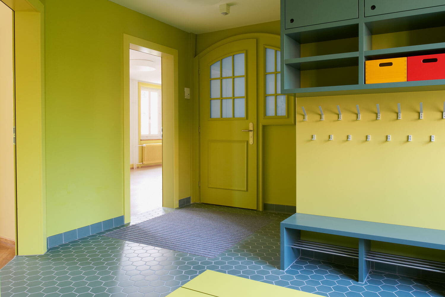 Garderobe des Kindergartens der Wohnsiedlung Schindelhäuser in Zürich Wipkingen. Bunte Grüntöne.