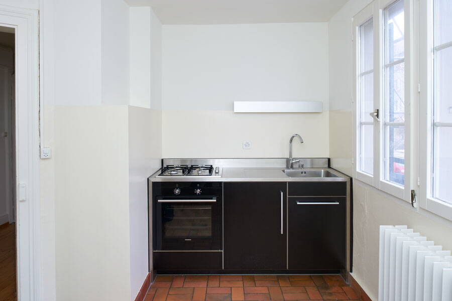 Schindelhäuser, Zürich Wipkingen, Küche nach der Renovation, schwarzes Küchenmodul mit Chromstahlabdeckung